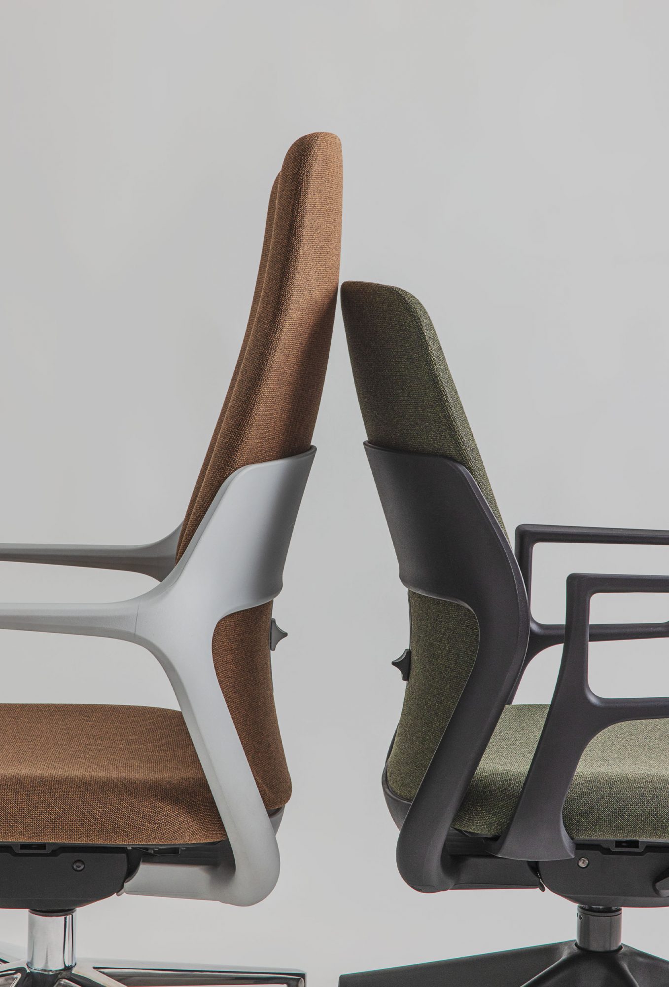 Two OFY chairs by Narbutas, designed by Alegre Design. The chairs feature an innovative thermoplastic back, customizable finishes in brown and green, and a button to adjust lumbar height, ideal for ergonomic support in modern workspaces.